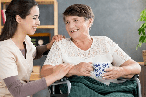 Caregiver engaging with a pensioner while having tea