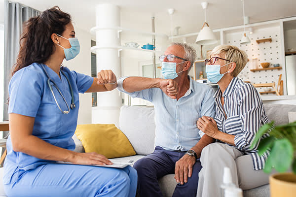 home nurse and man and woman wearing face masks
